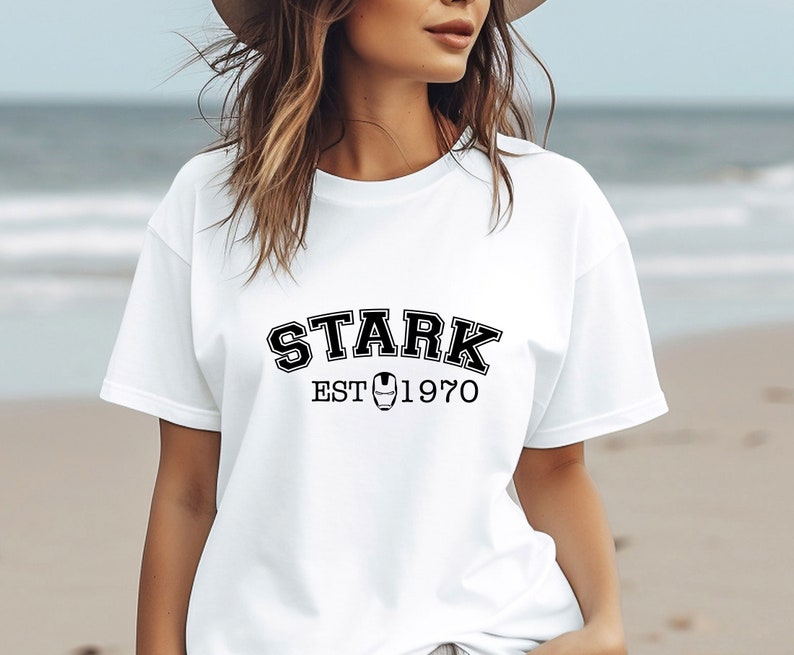 May include: White t-shirt with black text that reads "STARK EST 1970" with a small iron man logo in between the words.