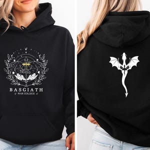 Peut inclure: Sweat-shirt à capuche noir avec des graphiques blancs. Le devant présente le texte "BASGIATH WAR COLLEGE" dans un motif circulaire. Le dos affiche un graphique de dragon blanc. Vêtement décontracté et confortable.