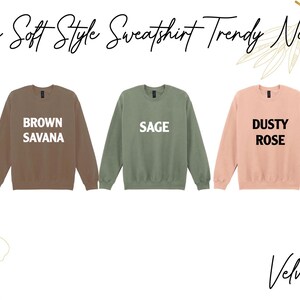 a collection of five different colored soft-style sweatshirts, each with a unique color and design, arranged in a row.