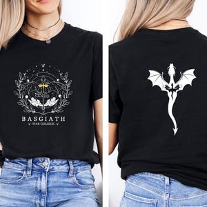 May include: Black t-shirt with a white graphic on the front and back. The front design features a sword, stars, and the text "BASGIATH WAR COLLEGE". The back displays a white dragon design.