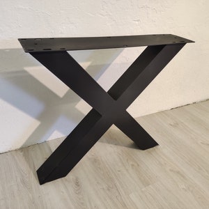 May include: Black metal table base with an X-shaped design. The base is made of thick metal and has a matte finish.