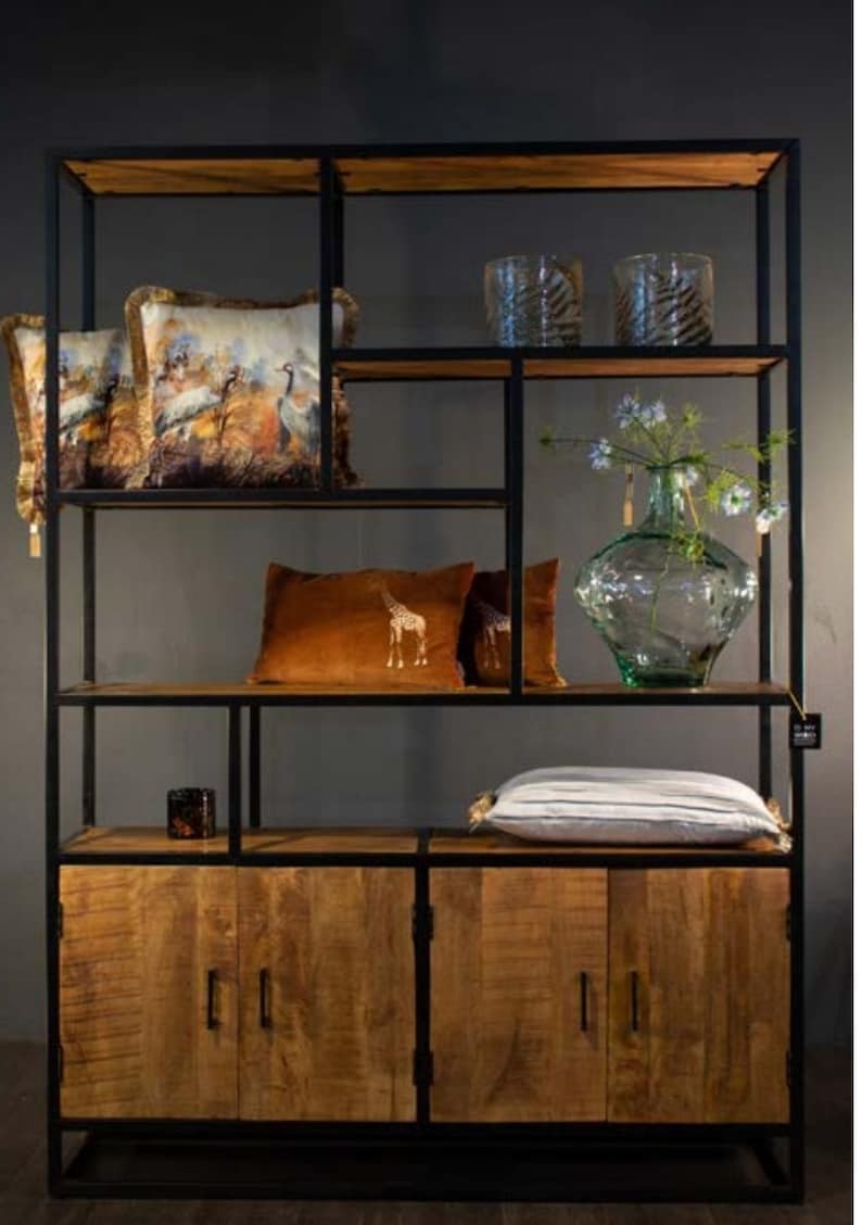 May include: A black metal and wood shelving unit with four doors. The shelves are filled with decorative items, including pillows, vases, and candles.