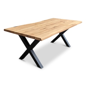 Könnte beinhalten: Ein Esstisch aus Holz mit einer natürlichen Holzoptik und schwarzen X-förmigen Beinen.