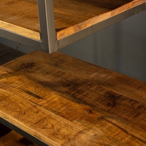 May include: A wooden shelf unit with a black metal frame. The shelves are made of natural wood with a warm brown color and a visible grain pattern.