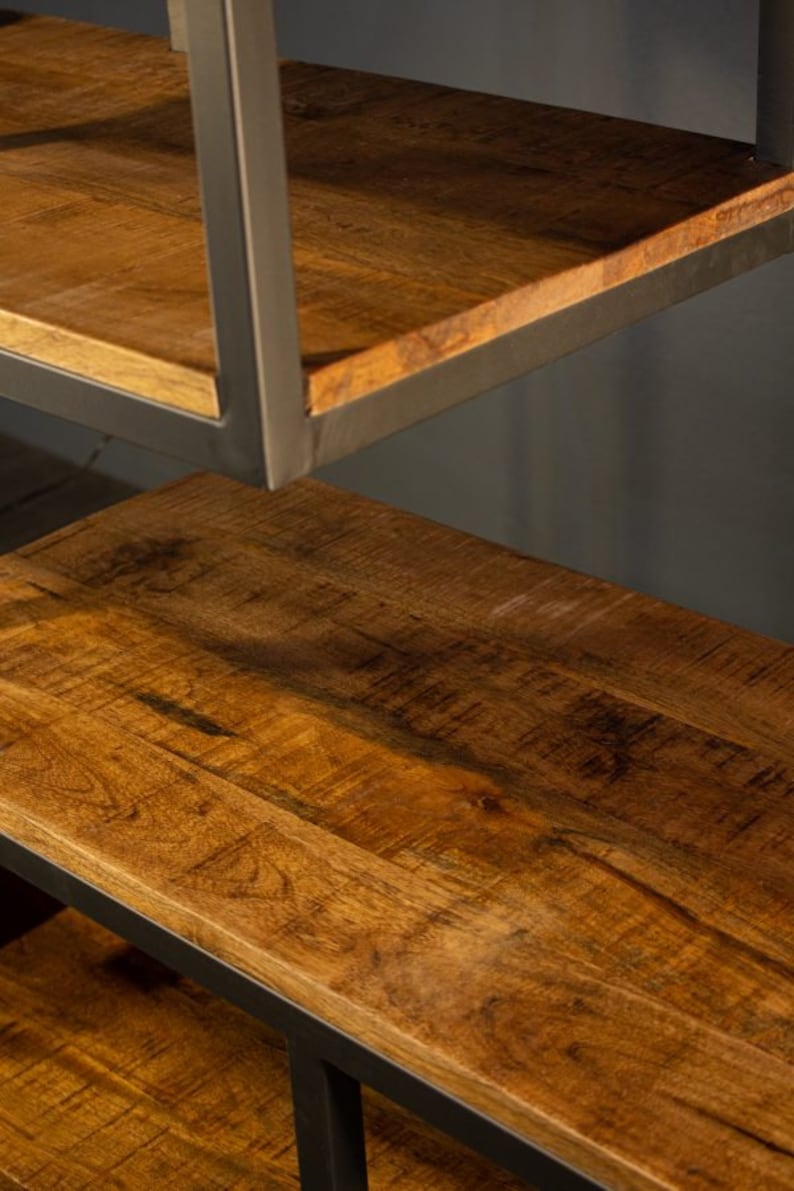 May include: A wooden shelf unit with a black metal frame. The shelves are made of natural wood with a warm brown color and a visible grain pattern.