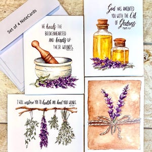 May include: Set of four note cards with watercolor illustrations. One card features a mortar and pestle with lavender, another shows oil bottles, and two others display lavender sprigs and herbs. Each card has a Bible verse.