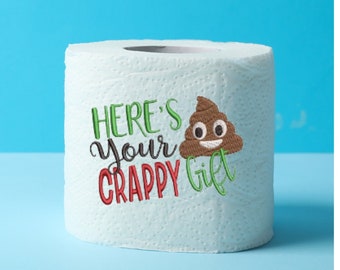 May include: A white toilet paper roll with green and red embroidery that says "Here's your crappy gift" and a brown poop emoji with a smiley face.
