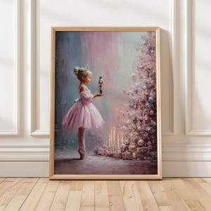 Puede incluir: Una impresión enmarcada representa a una joven bailarina con un tutú rosa sosteniendo un soldadito de juguete. Un árbol de Navidad decorado y velas están en el fondo. La obra de arte tiene una paleta de colores suaves y pastel con un ambiente soñador y caprichoso.