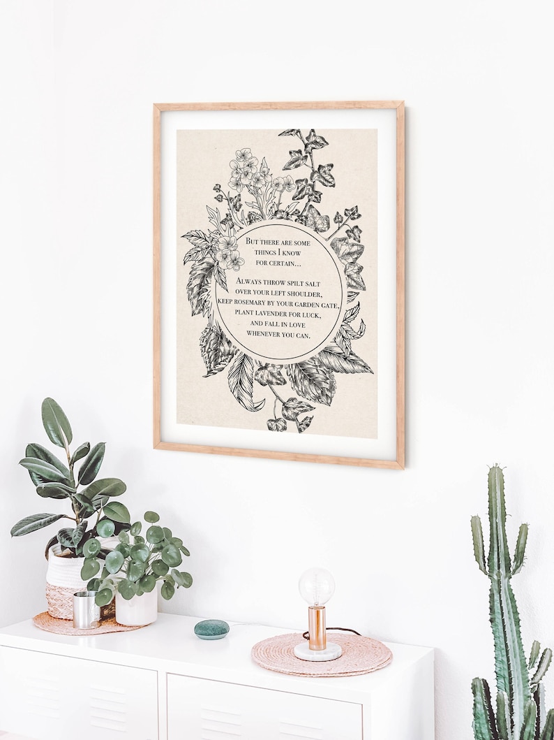 Vintage-inspired black and white botanical illustration featuring flowers and leaves framing a circular quote. The text inside reads: "But there are some things I know for certain… Always throw spilt salt over your left shoulder, keep rosemary by your garden gate, plant lavender for luck, and fall in love whenever you can." The artwork has an old-world, mystical feel, reminiscent of traditional herbal folklore or a page from an apothecary book.