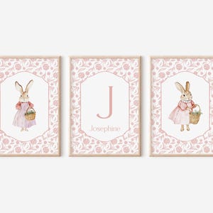 Puede incluir: Tres impresiones enmarcadas de flores rosas con un conejito sosteniendo una cesta de flores, la letra J y el nombre Josefina.