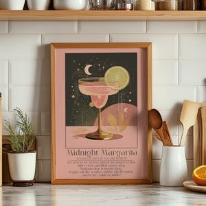 Puede incluir: Una impresión artística enmarcada que presenta un cóctel de margarita rosa con una rodaja de lima, sobre un fondo oscuro con estrellas y una luna creciente. La impresión incluye el texto "Midnight Margarita" y un poema.