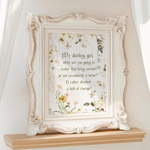 May include: A white framed print with a floral background and a quote that reads "My darling girl, when are you going to realize that being normal is not necessarily a virtue? It rather denotes a lack of courage!"