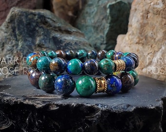 May include: Two beaded bracelets with gold accents. The bracelets are made of blue, green, and brown beads.