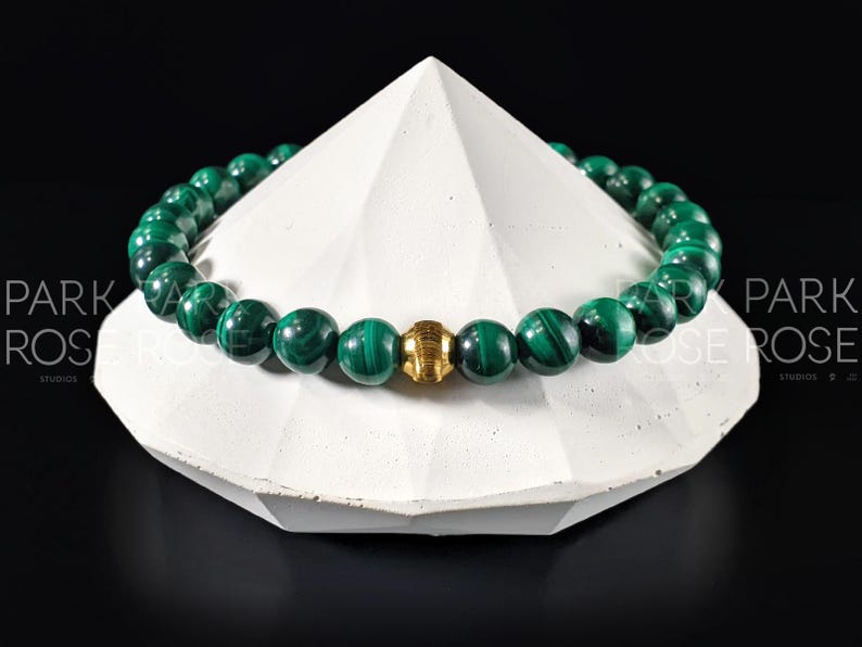 May include: A green malachite beaded bracelet with a gold accent bead.