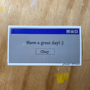 Puede incluir: Una ventana emergente de computadora azul y gris con el texto "Have a great day! :)" y un botón que dice "Okay".