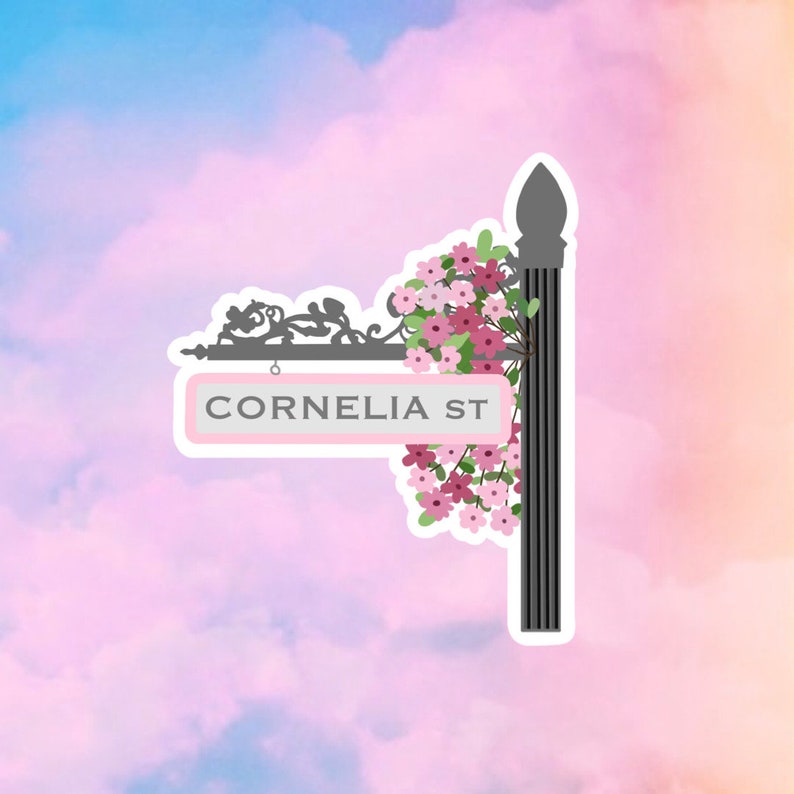 May include: A pink street sign with the text "CORNELIA ST" on a black metal frame with pink flowers hanging from it against a blue and pink cloudy background.