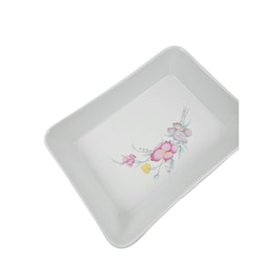 以下が含まれることがあります： 花柄の白い長方形のサービングディッシュ。花はピンク、イエロー、グリーンです。