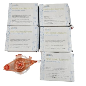 May include: A collection of Creative Memories Mini Frosted Segments Tape Runner Refill Cartridges. The boxes are white with blue text and floral designs. An orange tape runner is also visible.
