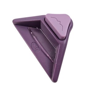 Könnte beinhalten: Ein lila Eckenschneider-Werkzeug mit dreieckiger Form. Das Werkzeug hat ein kleines, helllila Dreieck oben mit einem geschwungenen Design. Das Werkzeug hat den Buchstaben "M" in Schreibschrift an der Seite.