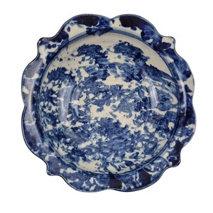 Bol de cerámica esponjosa azul cobalto con borde festoneado blanco y borde elevado.