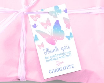 May include: A white thank you tag with a pink and blue butterfly design. The text on the tag reads "Thank you for celebrating my birthday with me! Love Charlotte".