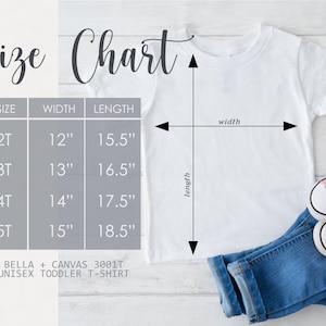 May include: A white unisex toddler t-shirt with a size chart. The chart shows sizes 2T to 5T, with corresponding width and length measurements in inches. The shirt is paired with blue jeans and pink sneakers.