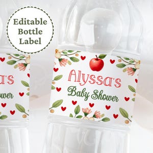 Op de afbeelding: Bewerkbaar waterfleslabel met een rode appel, roze bloemen, groene bladeren en rode hartjes. De tekst op het label luidt "Alyssa's Baby Shower".