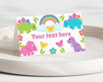 Puede incluir: Una tarjeta blanca con un arcoíris, nubes, mariposas y dinosaurios coloridos. El texto "Your text here" está impreso en la tarjeta.