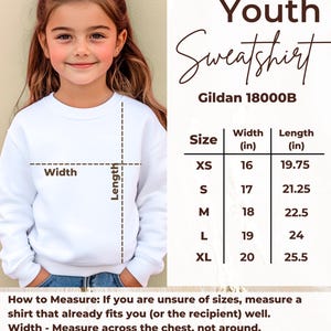 Peut inclure: Un sweat-shirt blanc pour jeunes avec un tableau des tailles et des instructions de mesure. Le sweat-shirt est pr&eacute;sent&eacute; sur une jeune personne. Le tableau des tailles indique les mesures en cm.