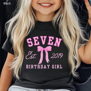 Peut inclure: T-shirt noir avec l'inscription rose "SEVEN Est. 2019 BIRTHDAY GIRL". Le motif comprend un n&oelig;ud rose. Il s'agit d'un v&ecirc;tement sur le th&egrave;me de l'anniversaire.