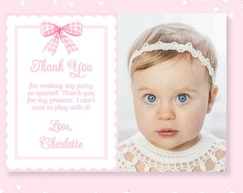 May include: Pink thank you card with a white scalloped border. The card features a pink and white gingham bow and a photo of a baby girl wearing a white headband. The text on the card reads "Thank You for making my party so special! Thank you for my present. I can't wait to play with it! Love, Charlotte"