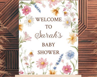 Può includere: Un cartello di benvenuto bianco con un bordo floreale. Il cartello dice "Benvenuti al baby shower di Sarah".