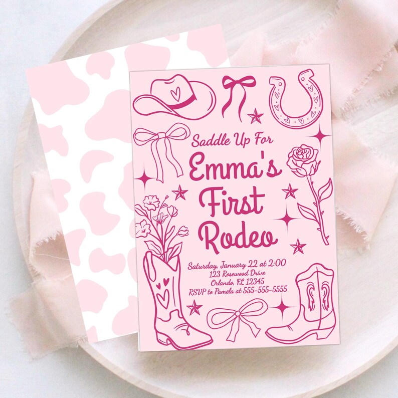 Puede incluir: Invitaci&oacute;n rosa con estampado de vaca en la parte trasera y tem&aacute;tica de rodeo. La parte delantera presenta un sombrero de vaquero, herradura, botas y el texto "Saddle Up For Emma's First Rodeo". Incluye detalles del evento.