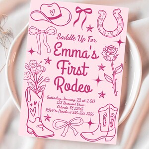 Puede incluir: Tarjeta de invitaci&oacute;n rosa con tem&aacute;tica de vaquero. La tarjeta presenta ilustraciones de un sombrero de vaquero, herradura, botas y lazos. El texto incluye "Saddle Up For Emma's First Rodeo" y detalles del evento.