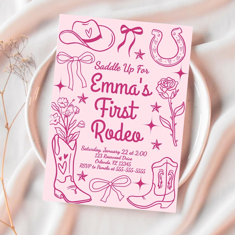 Puede incluir: Tarjeta de invitaci&oacute;n rosa con tem&aacute;tica de vaquero. La tarjeta presenta ilustraciones de un sombrero de vaquero, herradura, botas y una rosa. El texto dice "Saddle Up For Emma's First Rodeo". Incluye detalles del evento.
