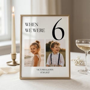Puede incluir: Un marco dorado con el texto "WHEN WE WERE 6" y dos fotos de niños. La parte inferior del marco dice "VICTORIA & JOHN 07.10.2027". El marco está sobre una superficie blanca.