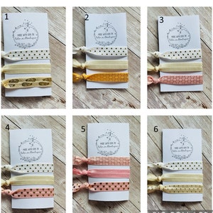 May include: Six sets of hair ties, each set contains three hair ties with different patterns. The hair ties are on white cards with the text "Made with love by Bolo Boutique".