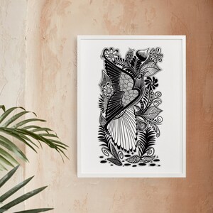 May include: Black and white line art print of a bird with intricate details, surrounded by floral elements. The print is framed in a white frame and displayed on a light brown wall.