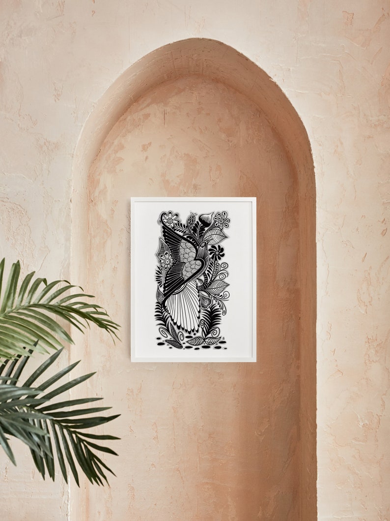 May include: Black and white line art print of a bird with intricate details, surrounded by floral elements. The print is framed in a white frame and displayed on a light brown wall.