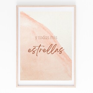 May include: A framed print with a watercolor background in shades of peach and cream. The text "y todas mis estrellas" is written in brown cursive script.
