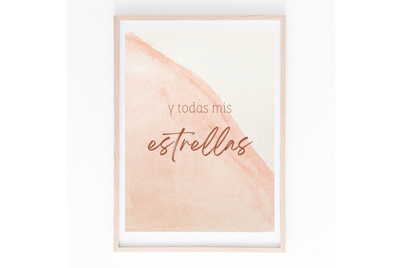 May include: A framed print with a watercolor background in shades of peach and cream. The text "y todas mis estrellas" is written in brown cursive script.