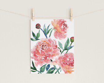 May include: Watercolor painting of pink peonies with green leaves and buds. The floral artwork is displayed on a white background and held by wooden clothespins on a string. The painting has a soft, delicate aesthetic.