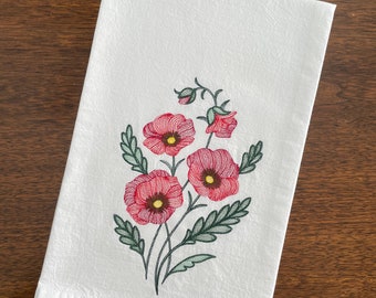 May include: White kitchen towel with embroidered red flowers and green leaves.