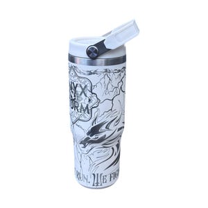 May include: White insulated drinks tumbler featuring a black and white dragon design and the text "NYX STORM". The tumbler has a white handle and lid. The design includes lightning bolts and the words "RUN. WE FIGHT."