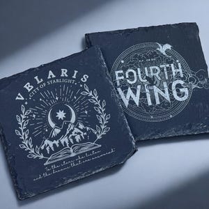 Peut inclure: Deux sous-verres en ardoise noire avec des motifs blancs. Le premier sous-verre repr&eacute;sente une cha&icirc;ne de montagnes, une lune croissante et des &eacute;toiles avec le texte "VELARIS CITY OF STARLIGHT" et "To the stars she listens and the dreams that are remembered". Le deuxi&egrave;me sous-verre pr&eacute;sente un motif circulaire avec le texte "FLY OR DIE FOURTH WING".