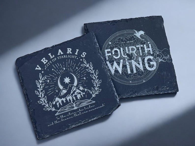 Peut inclure: Deux sous-verres en ardoise noire avec des motifs blancs. Le premier sous-verre repr&eacute;sente une cha&icirc;ne de montagnes, une lune croissante et des &eacute;toiles avec le texte "VELARIS CITY OF STARLIGHT" et "To the stars she listens and the dreams that are remembered". Le deuxi&egrave;me sous-verre pr&eacute;sente un motif circulaire avec le texte "FLY OR DIE FOURTH WING".