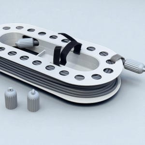 May include: A gray and white cable organizer with a series of oval holes and a black strap. Two gray caps are in the foreground. The organizer is designed to hold and manage cables, keeping them neat and tidy.
