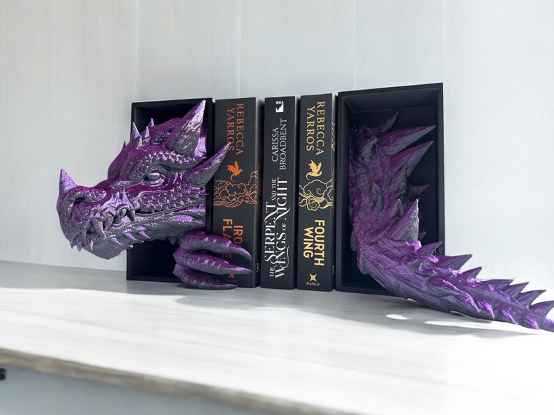 A purple dragon bookend elegantly supports a book, adding a whimsical touch to the bookshelf decor.