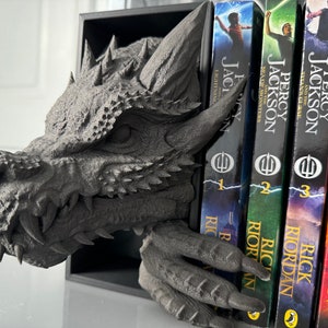 A decorative dragon head book holder with a book resting on top, combining fantasy and functionality in one piece.
