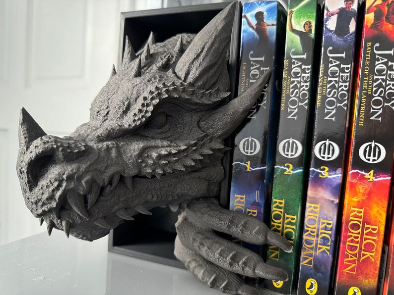 A decorative dragon head book holder with a book resting on top, combining fantasy and functionality in one piece.